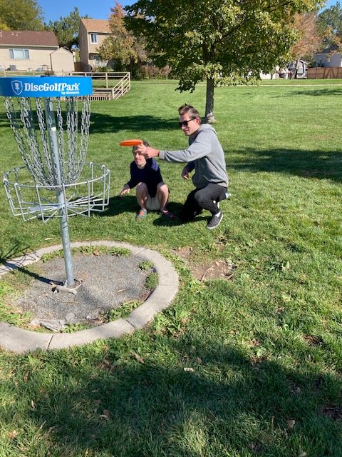 A client and staff throw a frisbee together