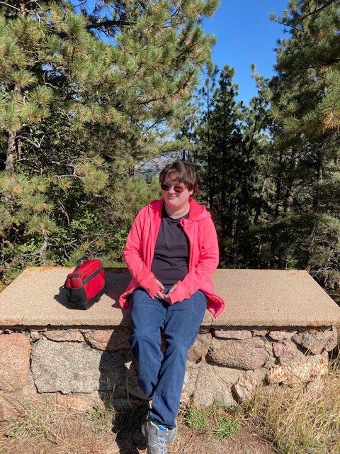 A client sits on a stone bench